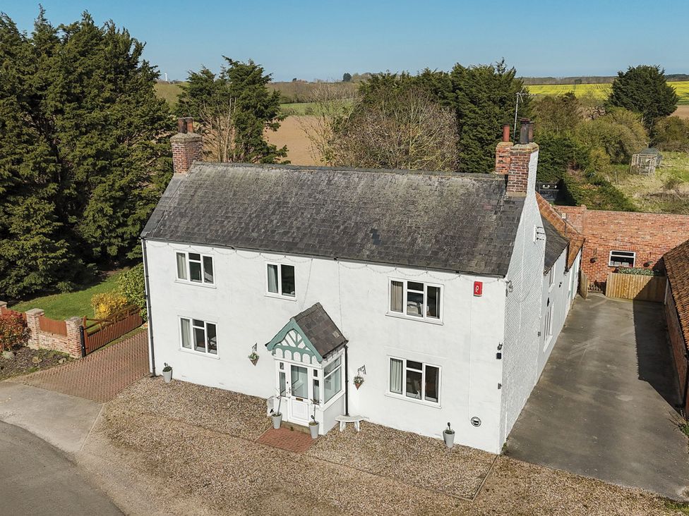 A house with a garden and driveway at Bewholme in Skipsea