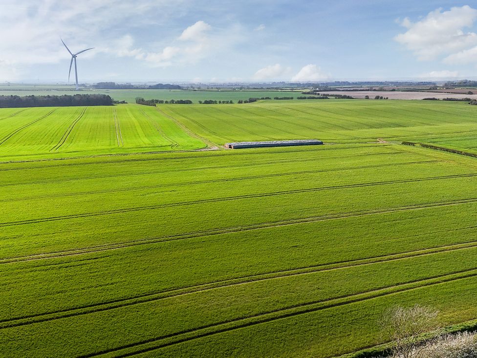 A landscape with wind turbine and green fields at Bewholme in Skipsea