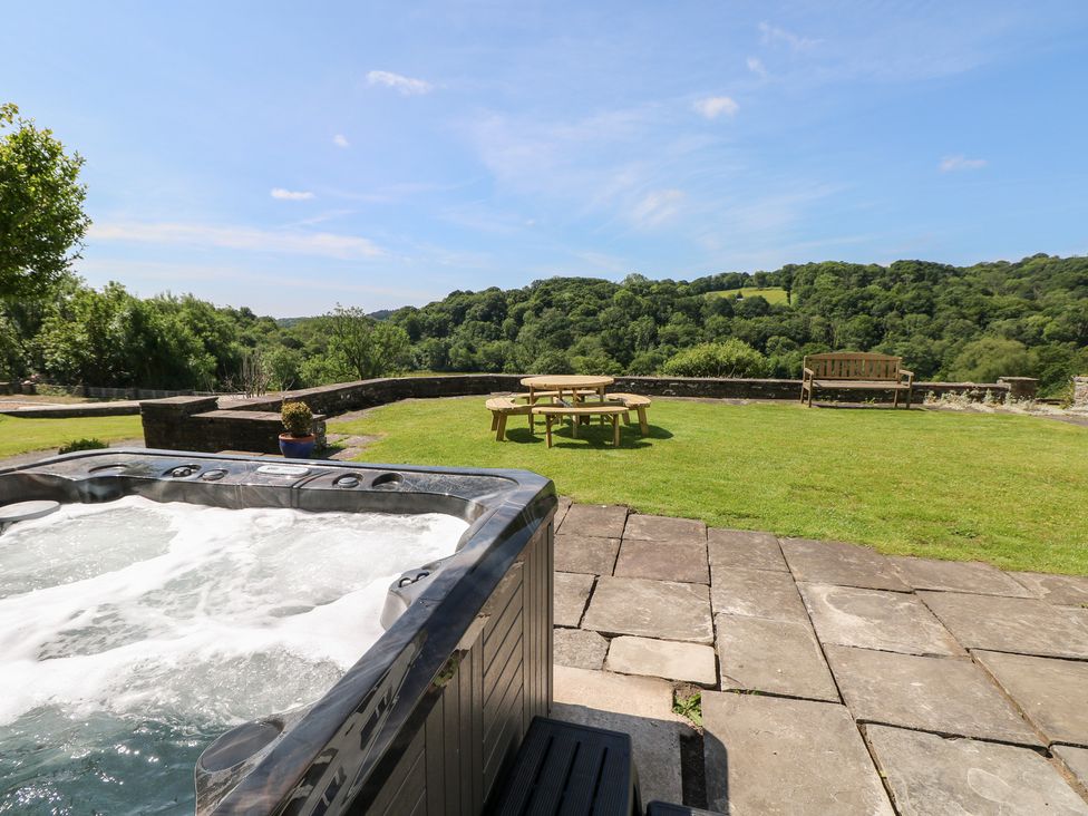 A garden with a hot tub and seating area at Coytrahen House near Bettws
