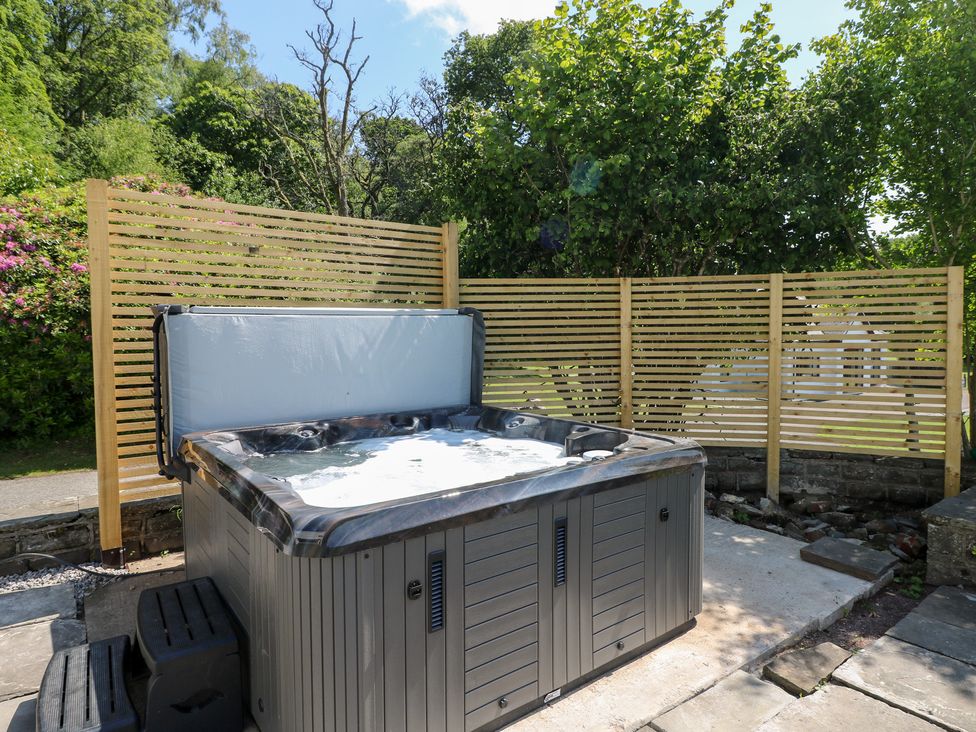 A hot tub surrounded by wooden slats in a garden at Coytrahen House Coytrahen near Bettws