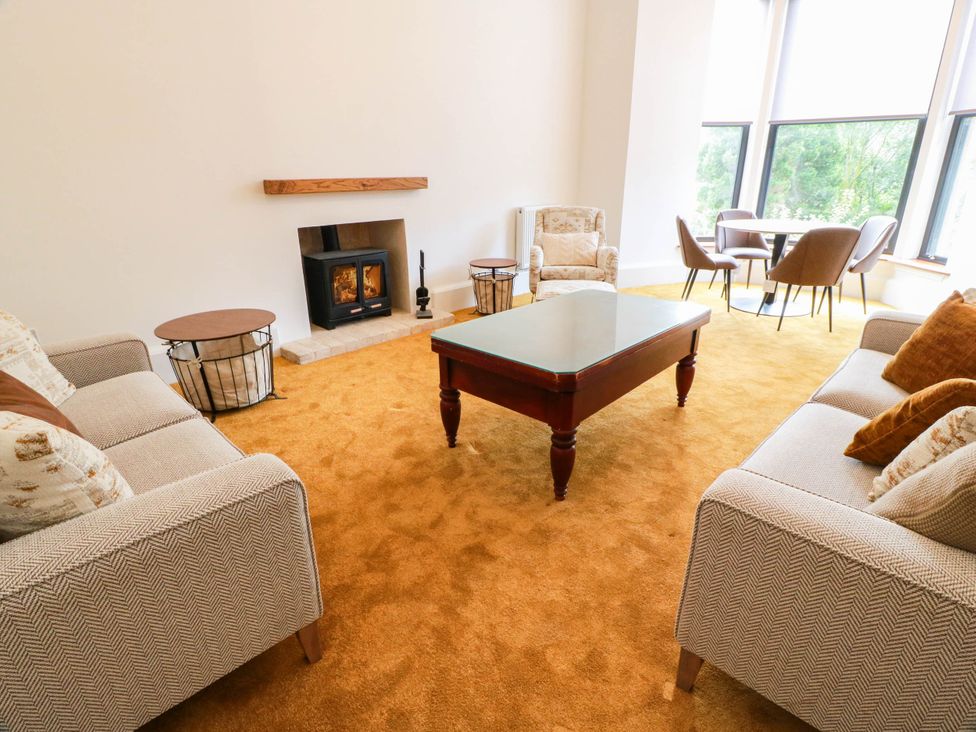 A living room with a fireplace and seating area at Winnocklands House