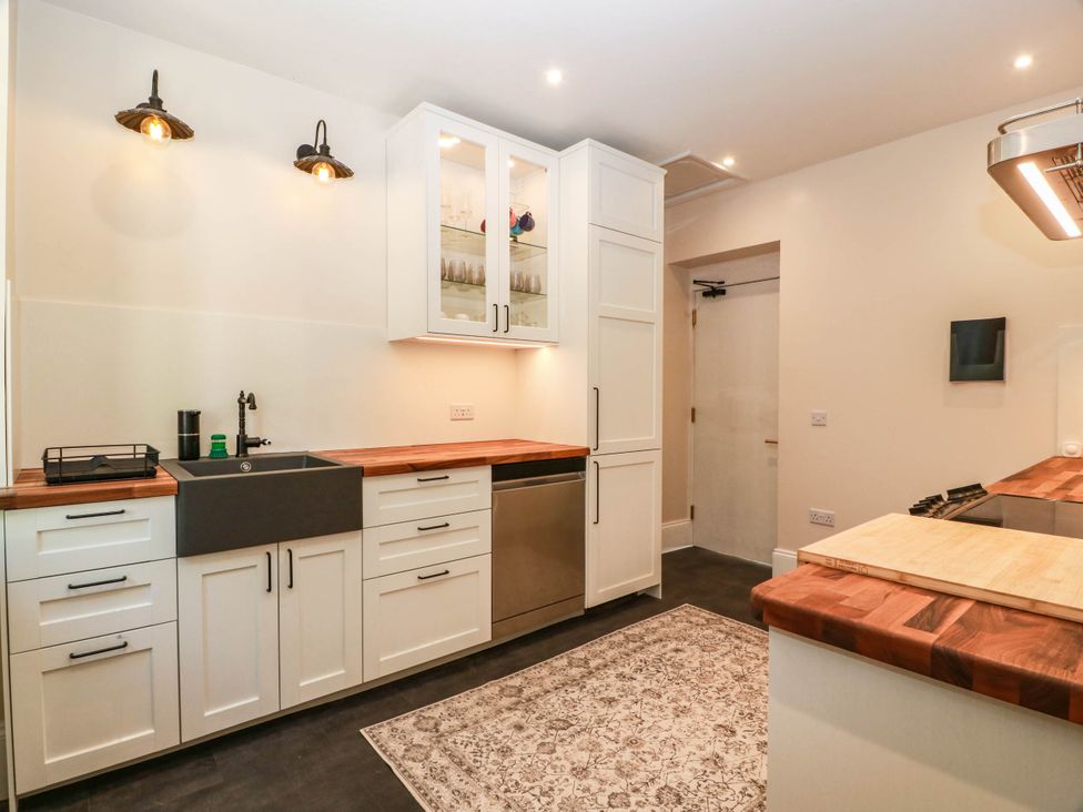 A kitchen with sink and cabinets at Winnocklands House