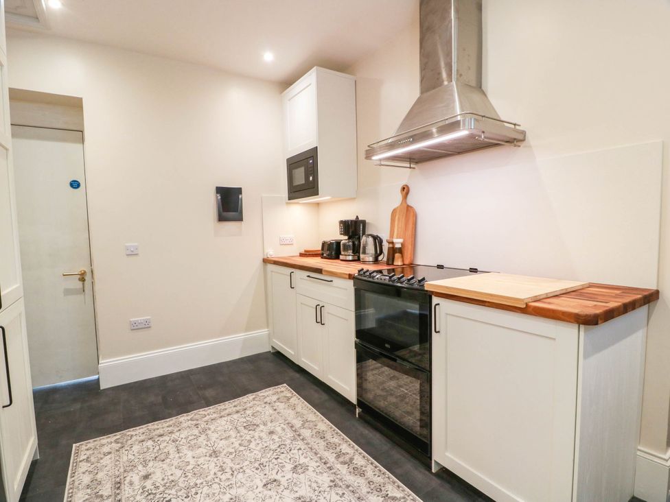 A kitchen with a cooking range and microwave at Winnocklands House