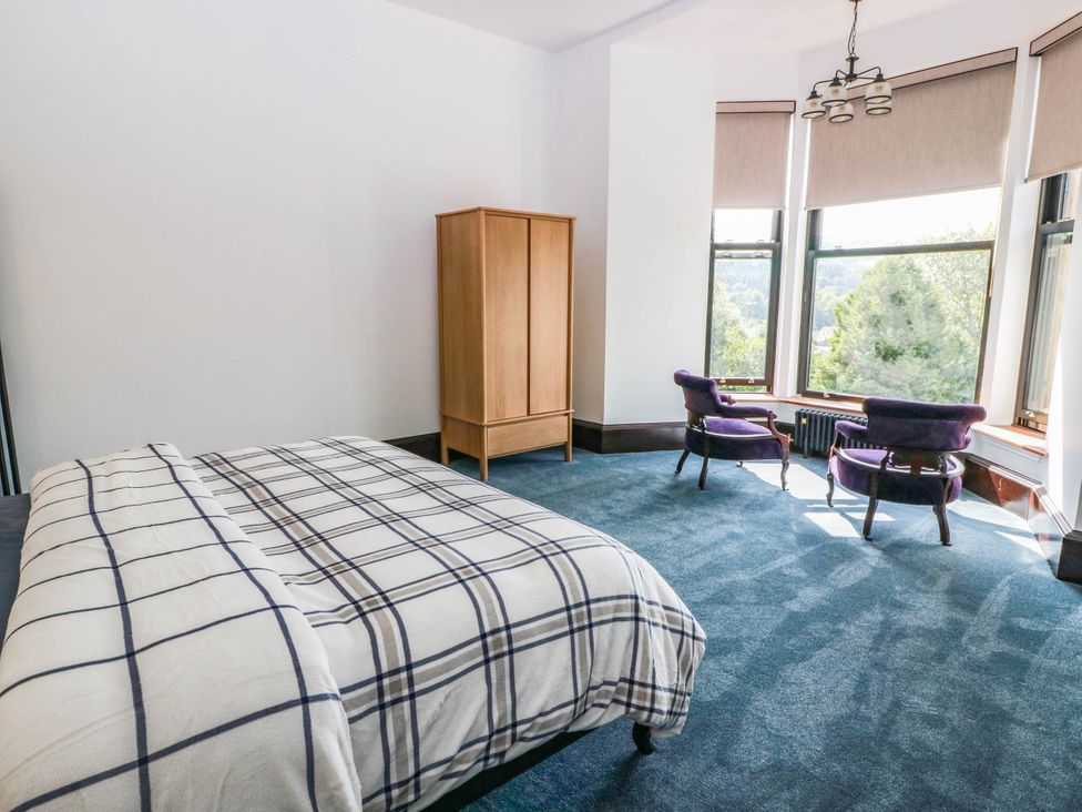 A bedroom with a bed and a wardrobe at Winnocklands House 