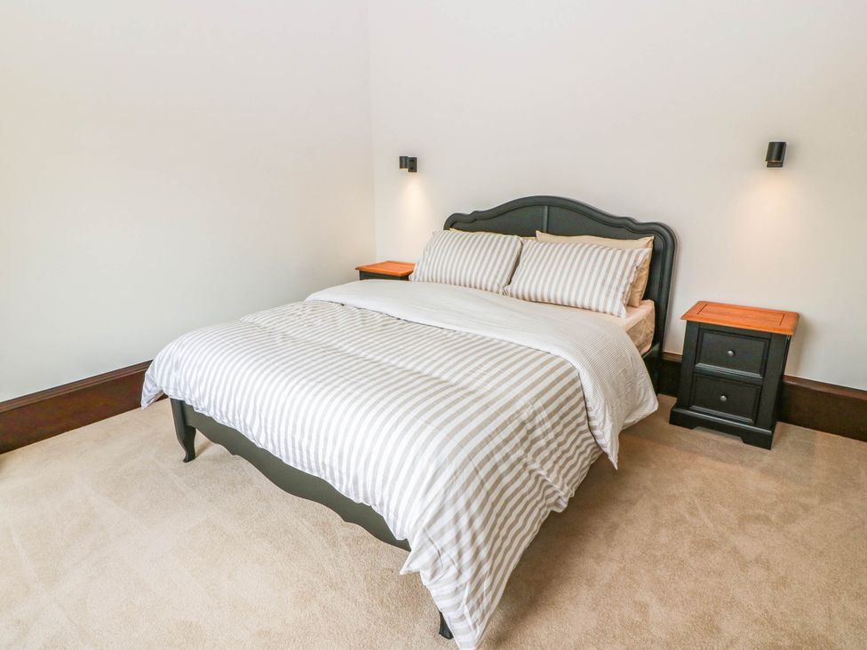 A bedroom with a bed and two nightstands at Winnocklands House