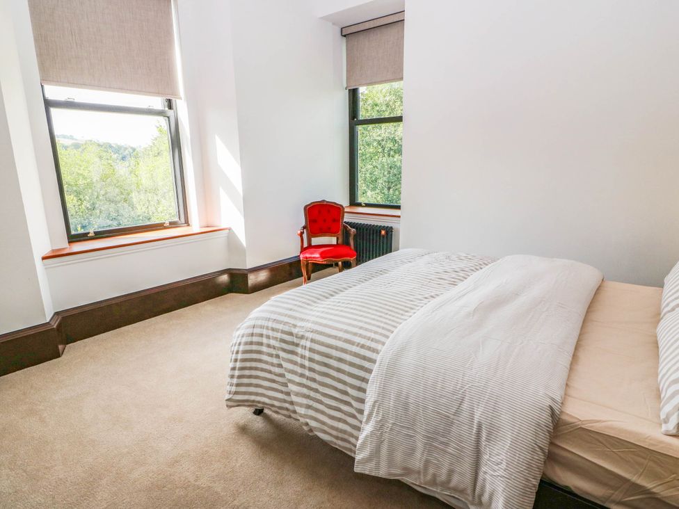 A bedroom with a bed and a red chair at Winnocklands House