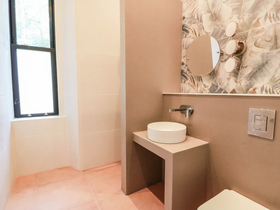 A bathroom with a sink, toilet, and mirror at Winnocklands House