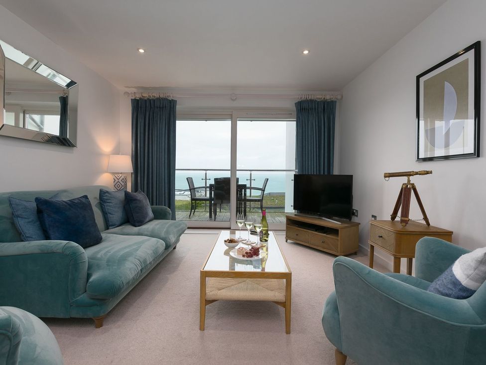 A living room with a sofa and television at Far Cliffs in St. Ives