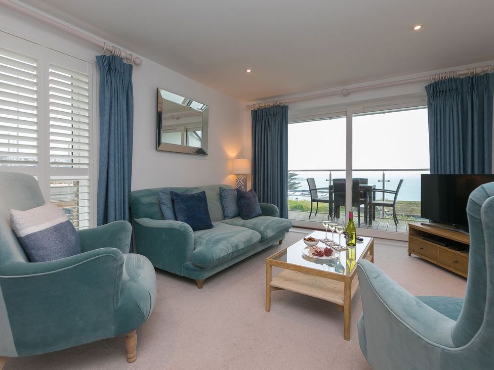 A living room with a sofa and TV at Far Cliffs in St. Ives