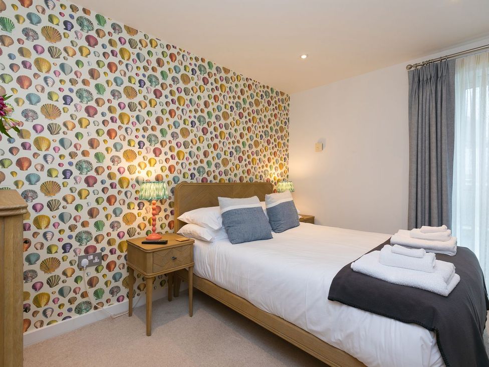 A bedroom with a bed and a bedside table at Far Cliffs in St. Ives