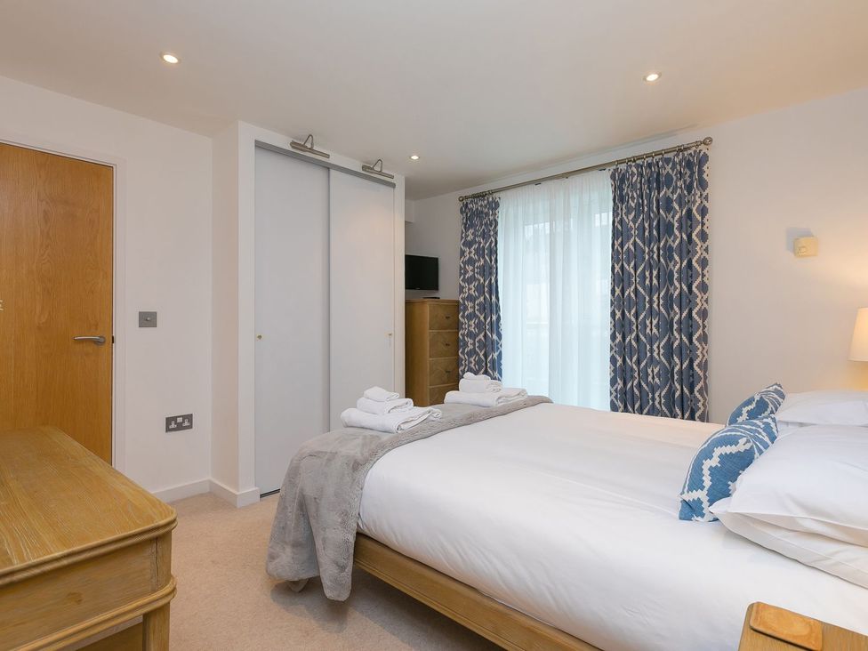 A bedroom with a bed and wardrobe at Far Cliffs in St. Ives