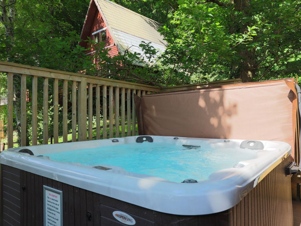 A hot tub on a wooden deck at Lodge 68 - Fern Gully near Finlakes Holiday Park in Chudleigh