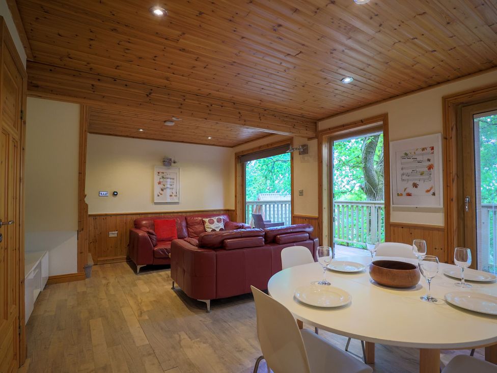 A living room with a sofa and dining table at Lodge 68 - Fern Gully near Finlakes Holiday Park near Chudleigh