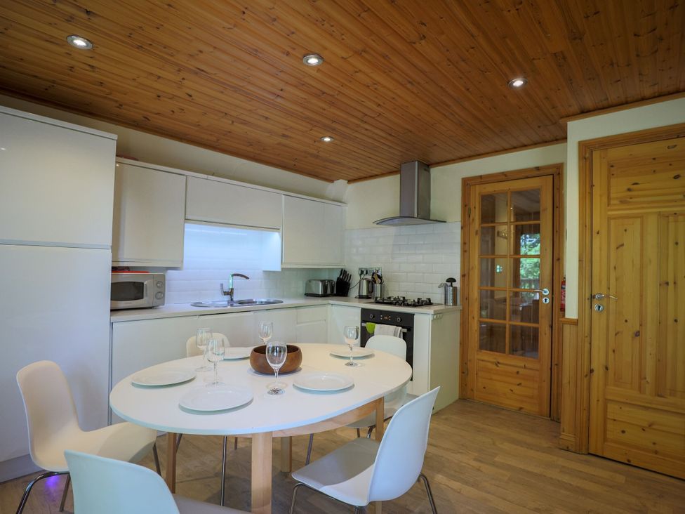 A kitchen with a table and chairs at Lodge 68 - Fern Gully near Chudleigh