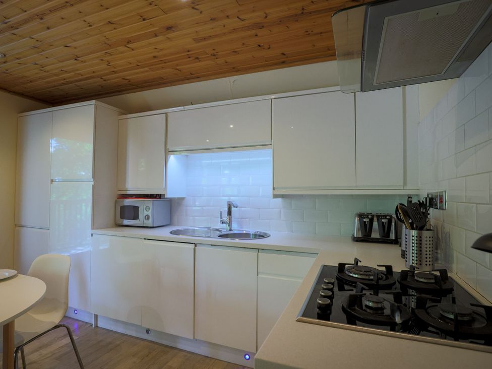 A kitchen with a sink and stove at Lodge 68 - Fern Gully near Chudleigh