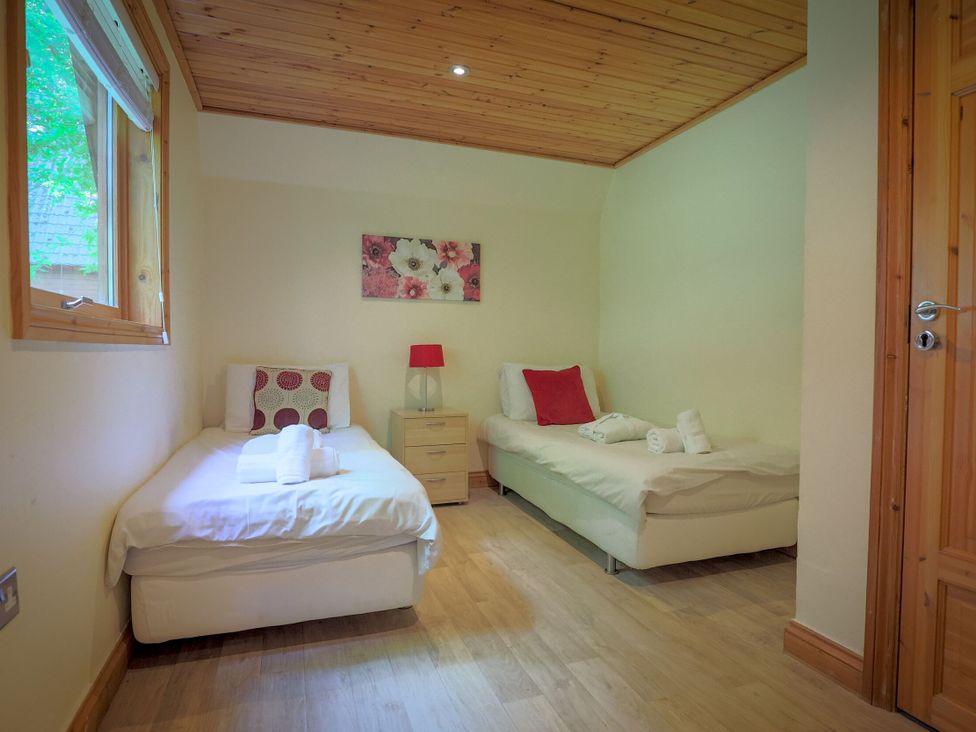 A bedroom with two single beds and a lamp at Lodge 68 - Fern Gully near Chudleigh