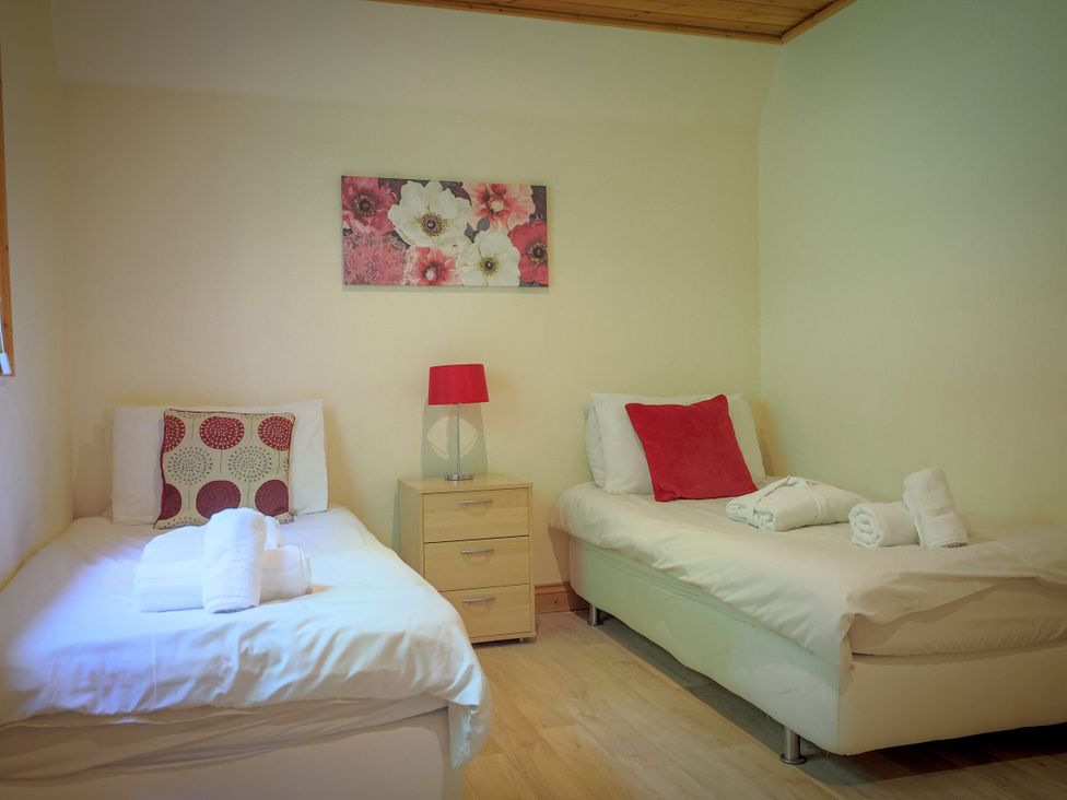 A bedroom with two beds and a nightstand at Lodge 68 - Fern Gully near Chudleigh