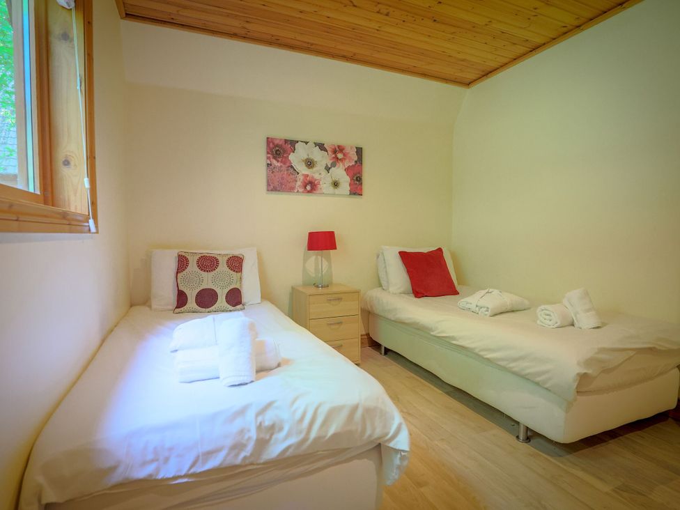 A bedroom with two beds and a lamp at Lodge 68 - Fern Gully near Chudleigh