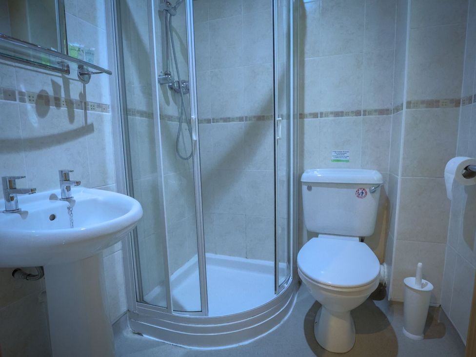 A bathroom with a shower, toilet, and sink at Lodge 68 - Fern Gully near Finlakes Holiday Park