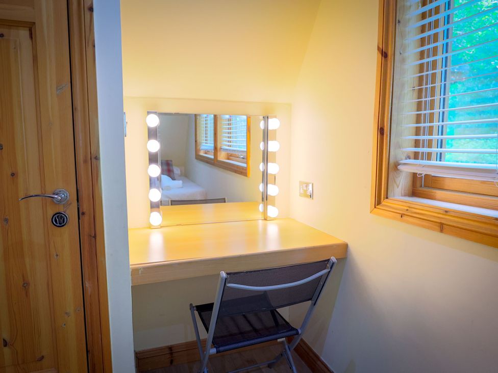 A dressing room with a vanity mirror and desk at Lodge 68 - Fern Gully near Finlakes Holiday Park