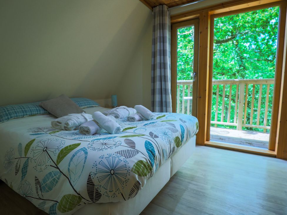 A bedroom with a bed and towels at Lodge 68 - Fern Gully near Finlakes Holiday Park