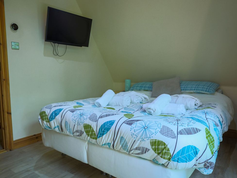 A bedroom with a bed and television at Lodge 68 - Fern Gully near Finlakes Holiday Park