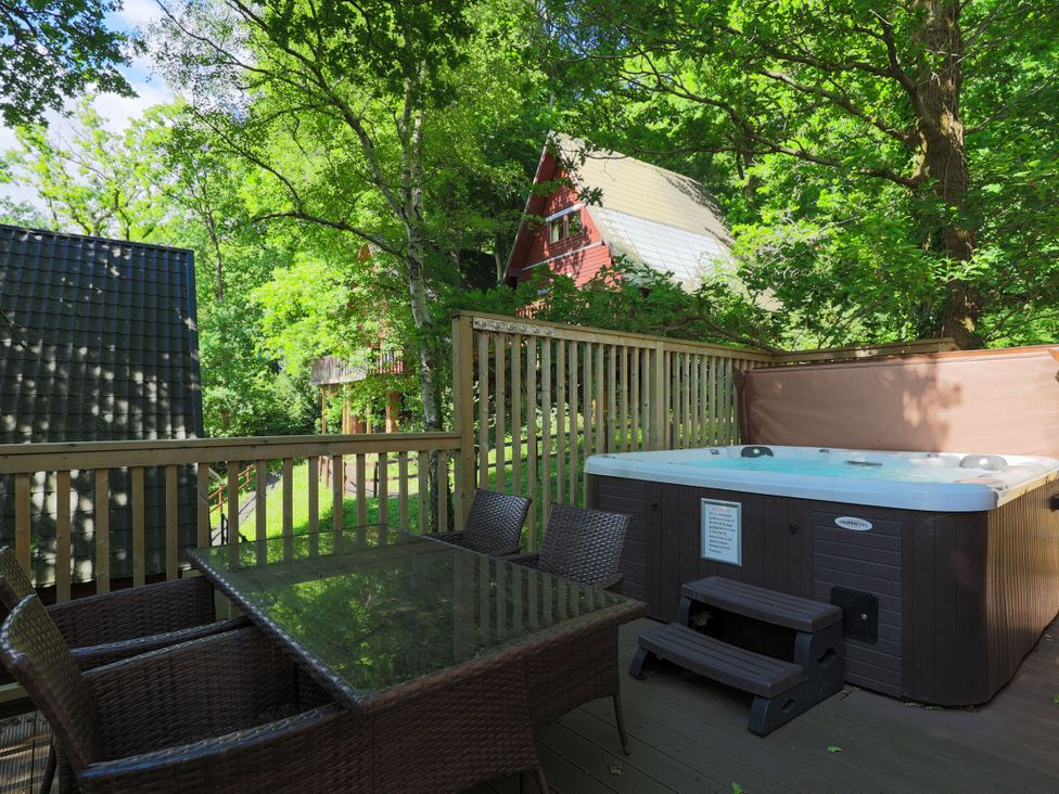 An outdoor area with a hot tub and dining set at Lodge 68 - Fern Gully, Finlakes Holiday Park near Chudleigh