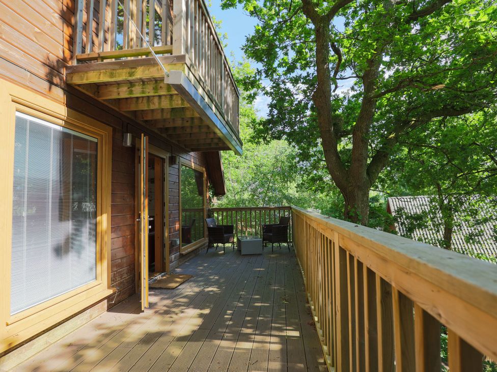 An outdoor deck with seating at Lodge 68 - Fern Gully near Finlakes Holiday Park