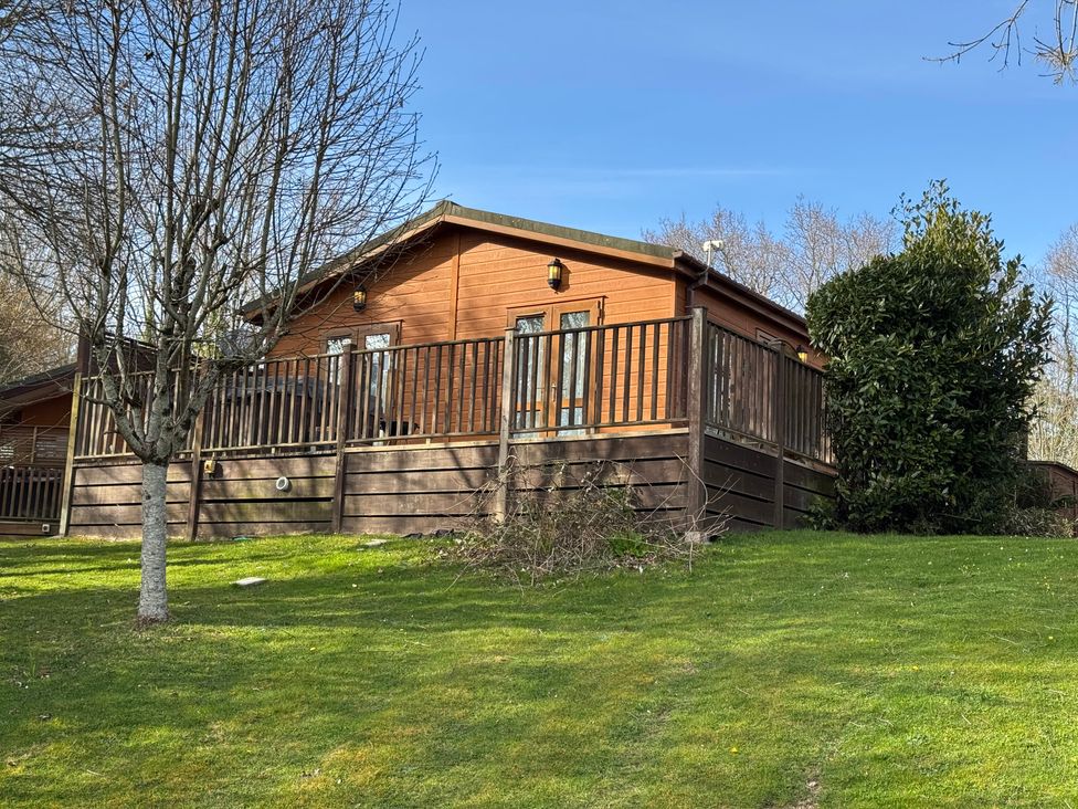 A lodge with decking and trees at Woodland View 31 - The Hawthorns near Chudleigh