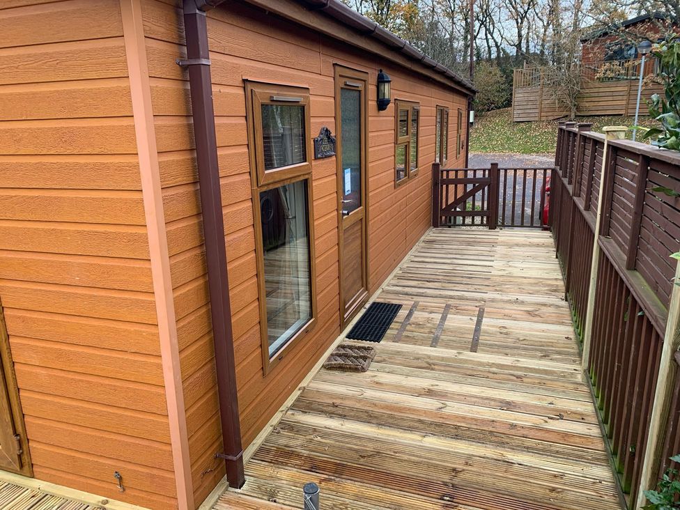 An outdoor area with a wooden cabin and deck at Woodland View 31 - The Hawthorns Finlakes Holiday Park near Chudleigh