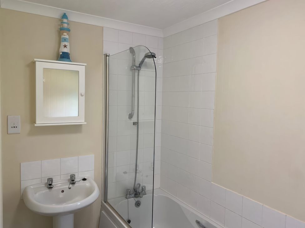 A bathroom with a bathtub, shower, sink and mirror at Woodland View 31 - The Hawthorns near Finlakes Holiday Park