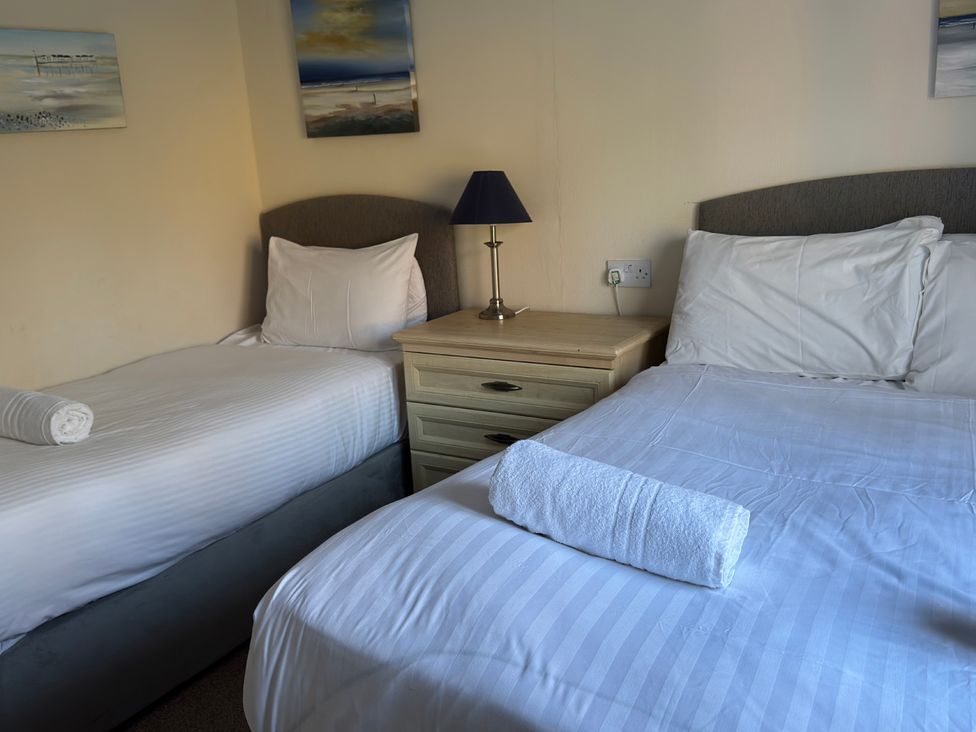 A bedroom with two beds and a nightstand at Woodland View 31 - The Hawthorns Finlakes Holiday Park near Chudleigh