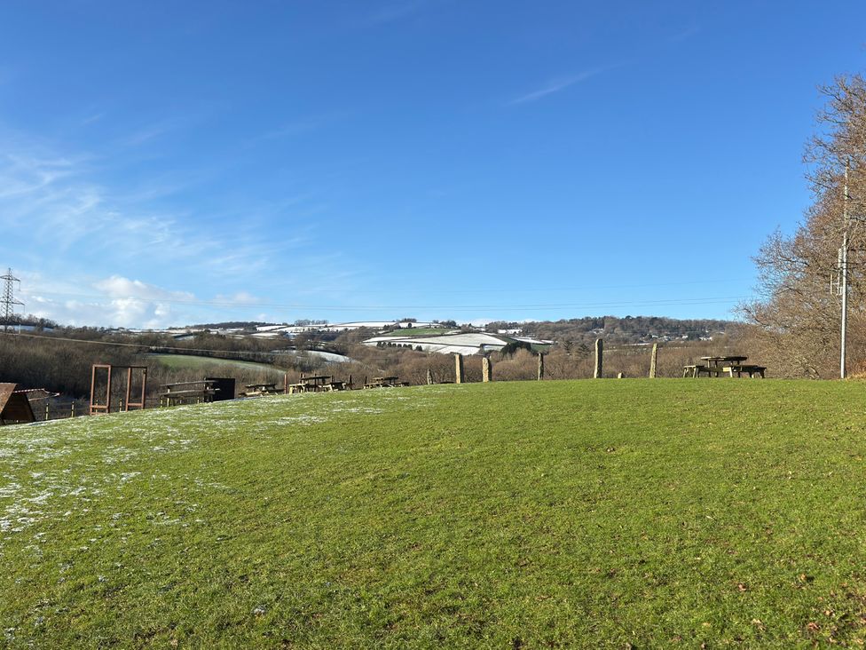 A grassy area with trees and tables at Woodland View 31 - The Hawthorns near Finlakes Holiday Park