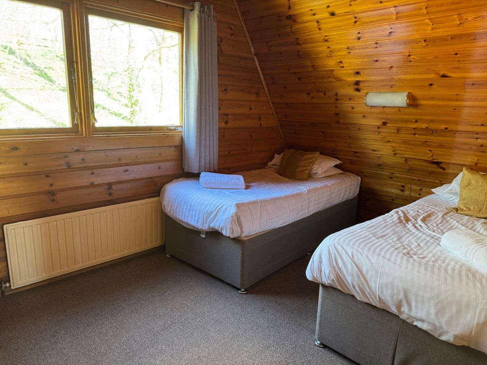 A bedroom with two beds and a window at Tor View Finlakes Holiday Park near Chudleigh