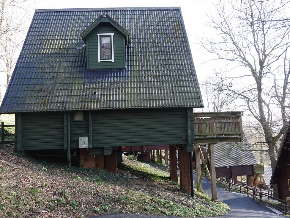A cabin with a sloped roof and balcony at Tor View in Finlakes Holiday Park near Chudleigh