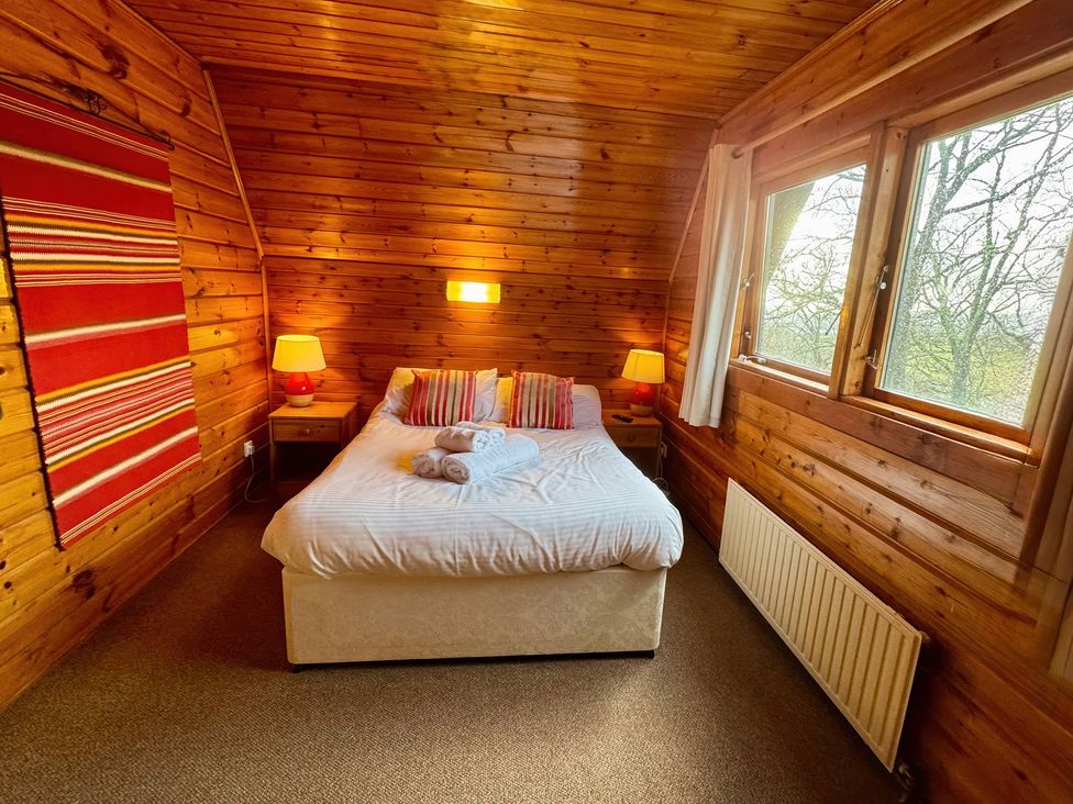 A bedroom with a bed and lamps at Tor View Finlakes Holiday Park near Chudleigh