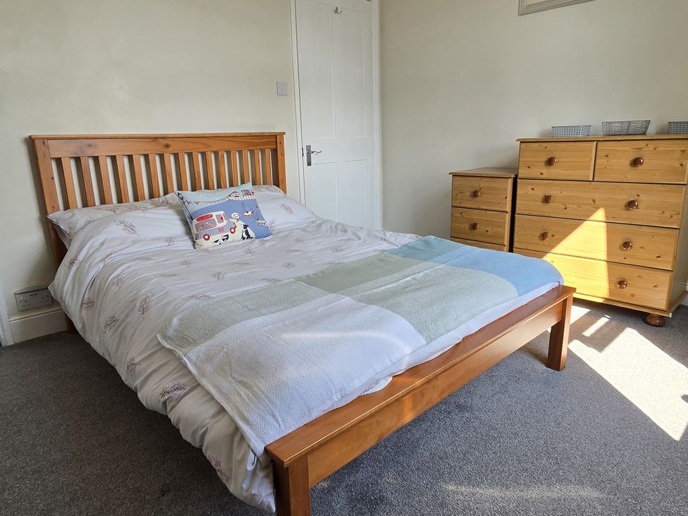 A bedroom with a bed and dresser at Harbour View in Whitby