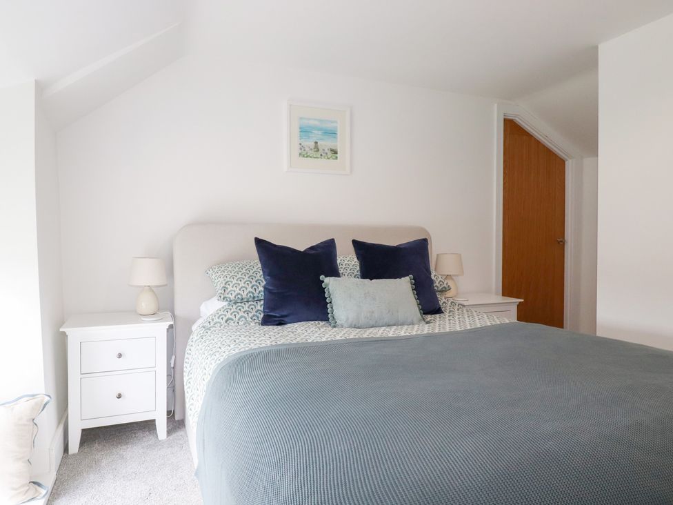 A bedroom with a bed and nightstands at Glendale in Port Isaac