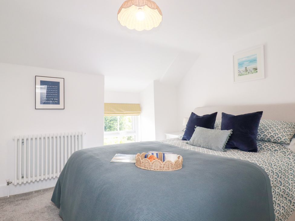 A bedroom with a bed and a window at Glendale in Port Isaac