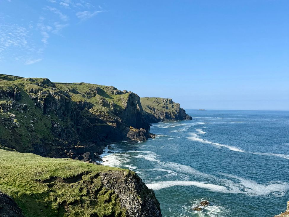 Cliffs by the ocean under a clear sky at Glendale Trelights near Port Isaac