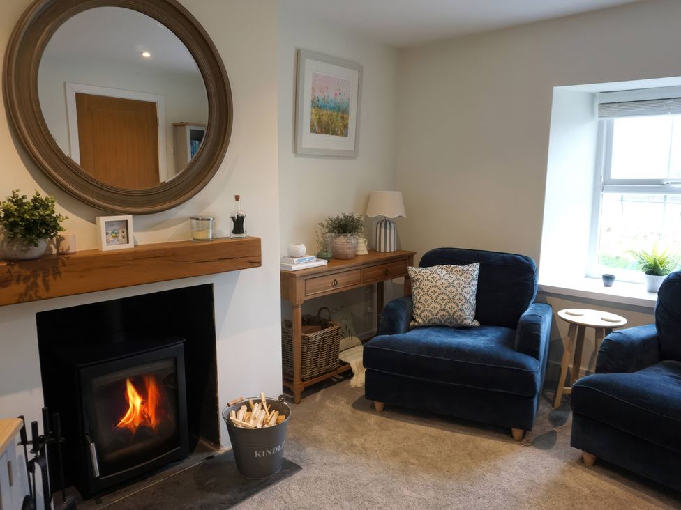 A living room with armchairs and a fireplace at Glendale Trelights near Port Isaac