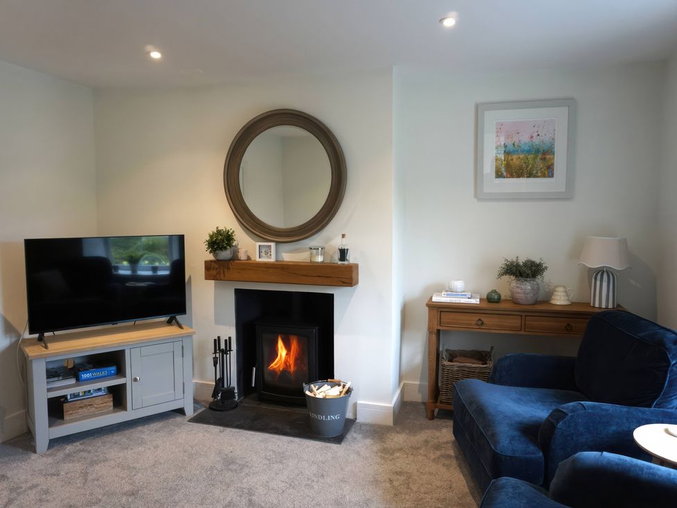 A living room with a fireplace and TV at Glendale Trelights near Port Isaac