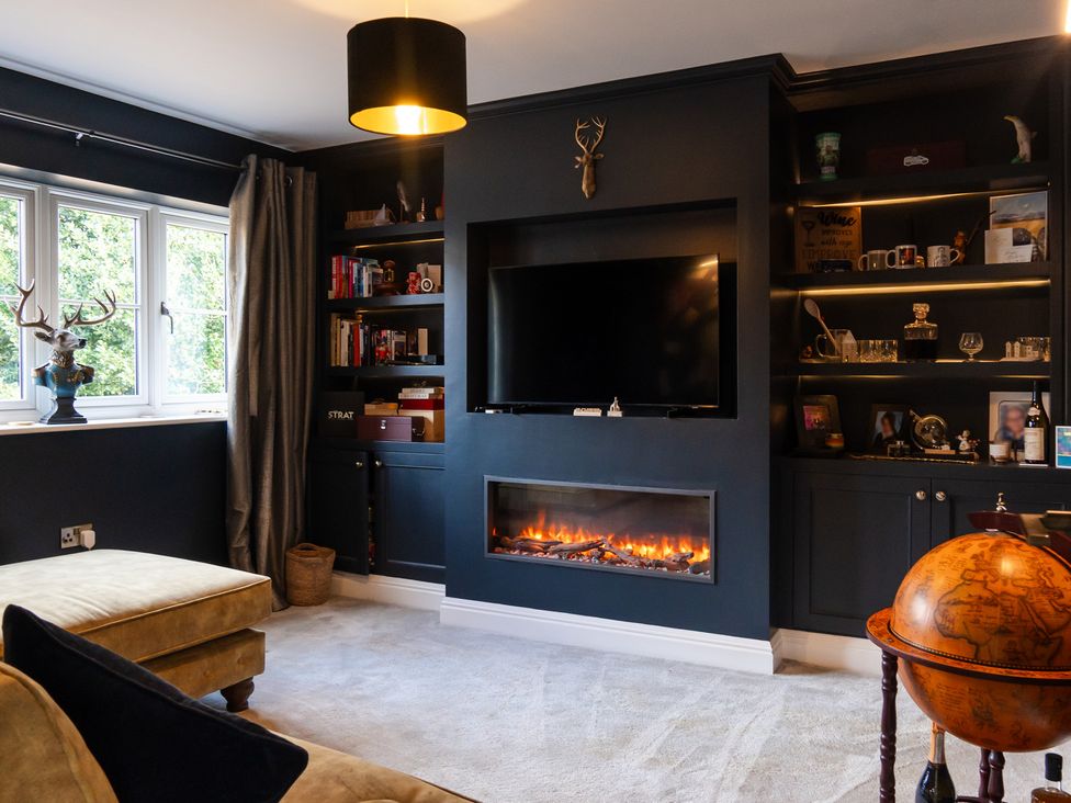 A living room with a television and a fireplace at 30 High Lane East in Ilkeston