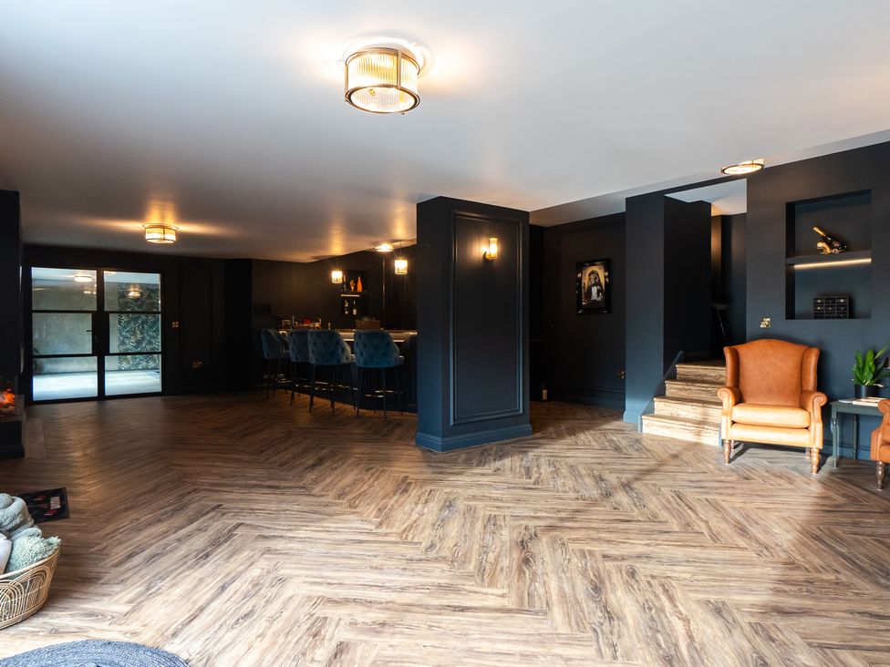A living room featuring a bar area and staircase at 30 High Lane East in Ilkeston