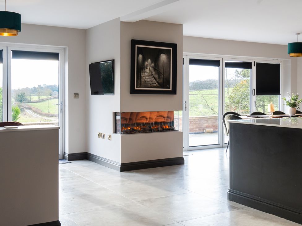 A living room with a fireplace and sliding doors at 30 High Lane East in Ilkeston