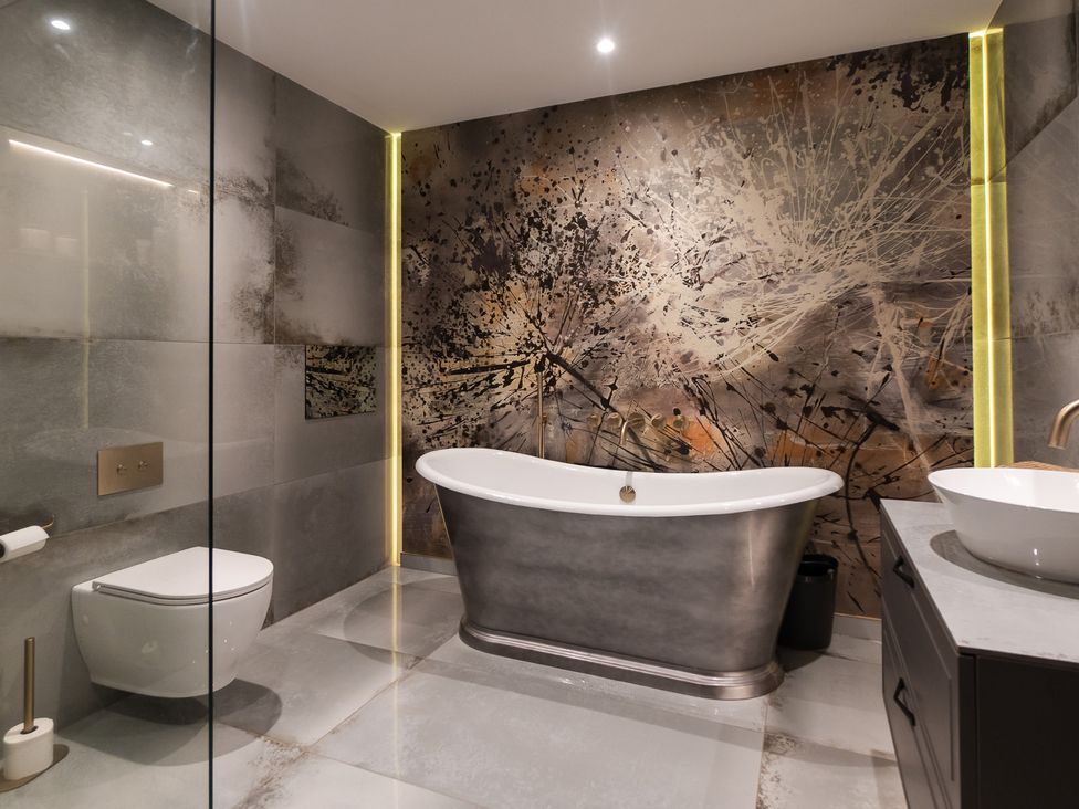 A bathroom with a bathtub, toilet, and sink at 30 High Lane East Ilkeston