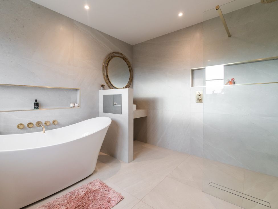 A bathroom featuring a bathtub and shower at 30 High Lane East Ilkeston