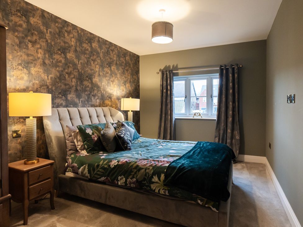 A bedroom with a bed and lamps at 30 High Lane East in Ilkeston