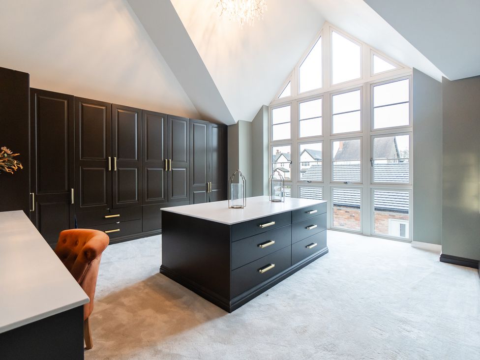 A bedroom with a wardrobe, chest of drawers and a window at 30 High Lane East in Ilkeston