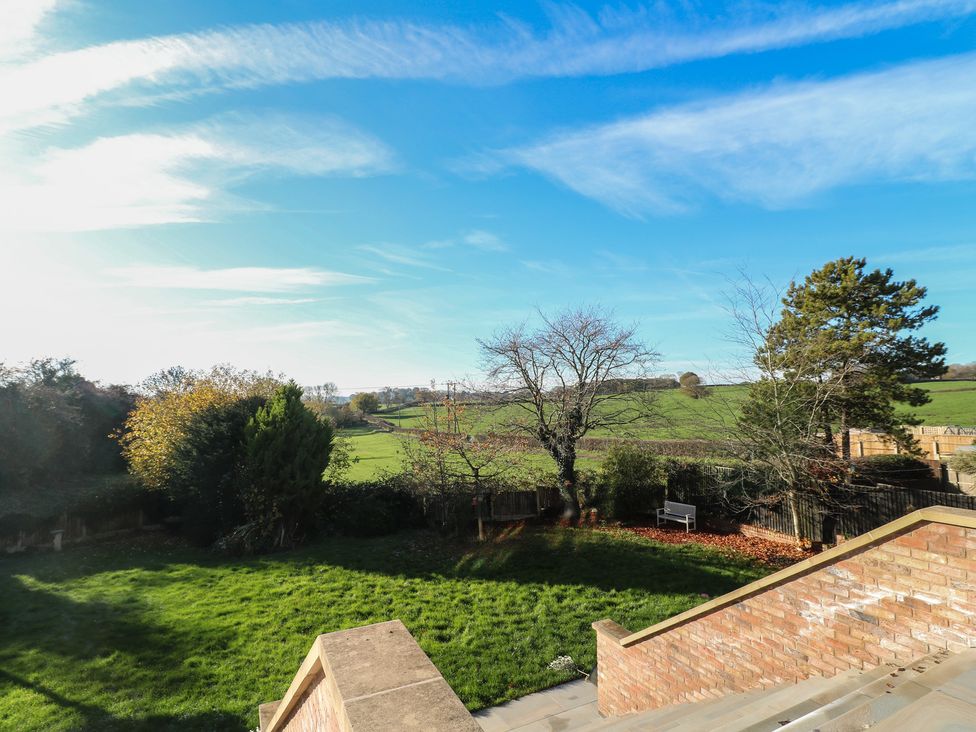 A garden with grass and trees at Hallam Retreat in West Hallam
